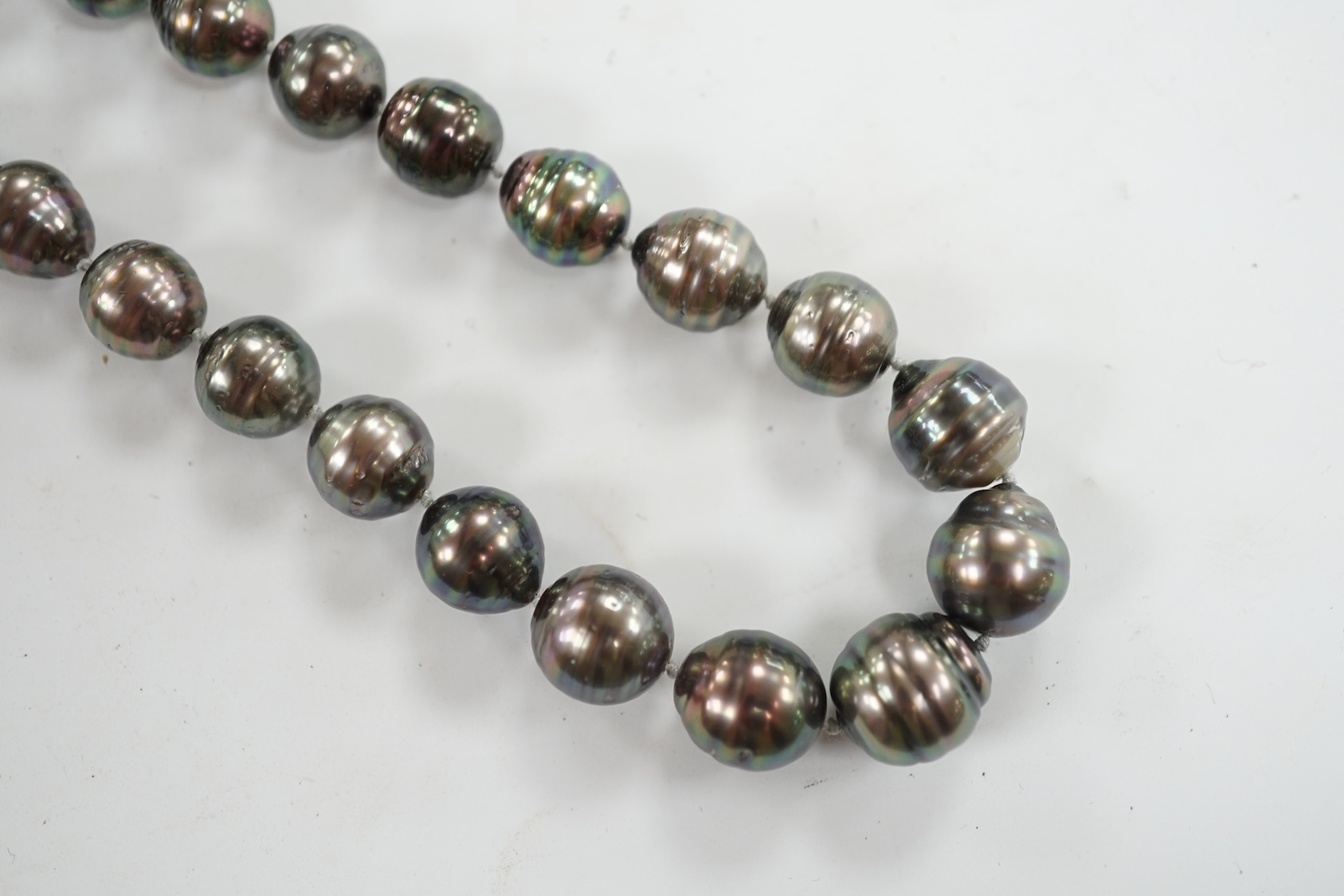 A modern single strand graduated Tahitian baroque cultured pearl necklace, with cabochon set yellow metal clasp, 48cm. Condition - fair to good